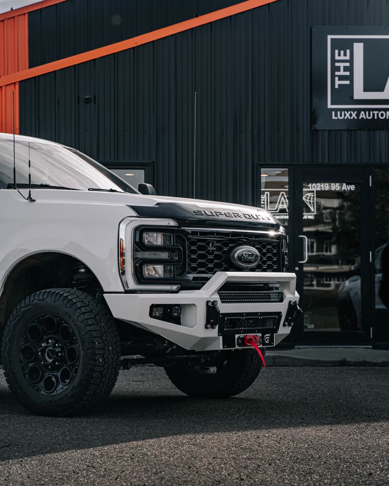 White Ford Super Duty with a Gridiron bumper in front of the THE LAB shop, 10219 95 Ave